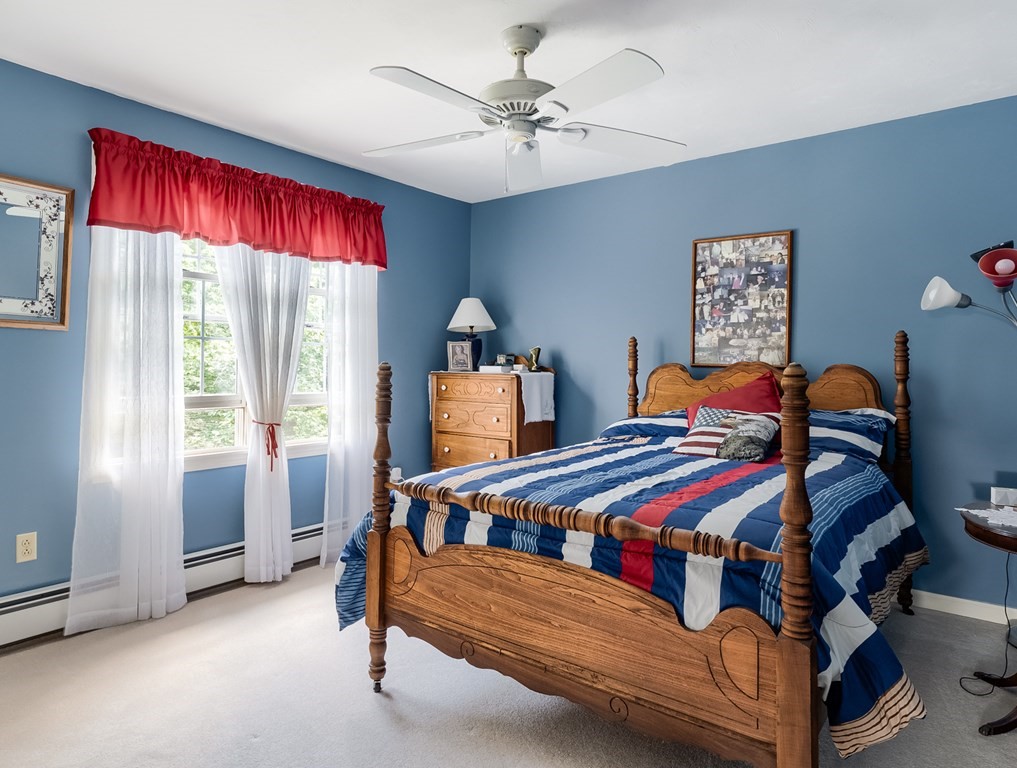 8 10 Rod Road Rutland, MA 01543 - Photo 18 of 32 a bedroom with a bed and a chandelier