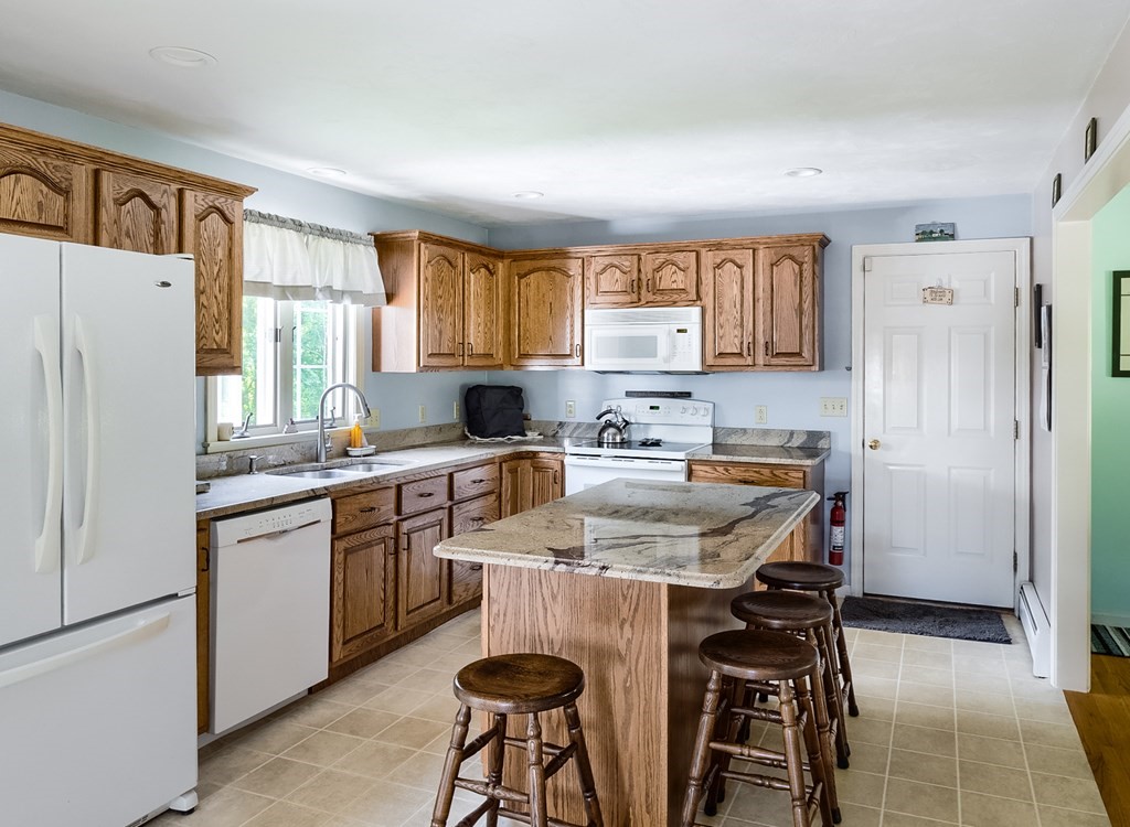 8 10 Rod Road Rutland, MA 01543 - Photo 5 of 32 a kitchen with stainless steel appliances granite countertop a table chairs sink refrigerator and cabinets