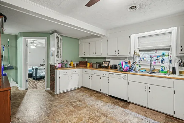 a kitchen with granite countertop white cabinets and white appliances