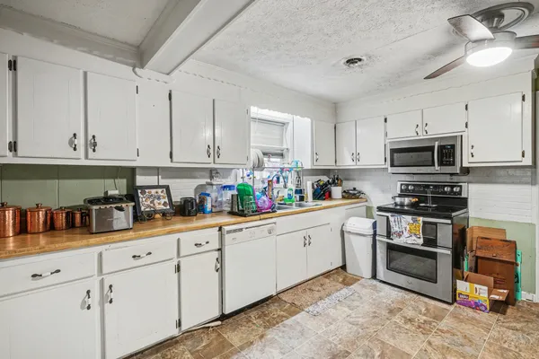 a kitchen with stainless steel appliances granite countertop a stove sink and cabinets