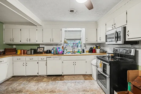 a kitchen with stainless steel appliances granite countertop a stove sink and cabinets