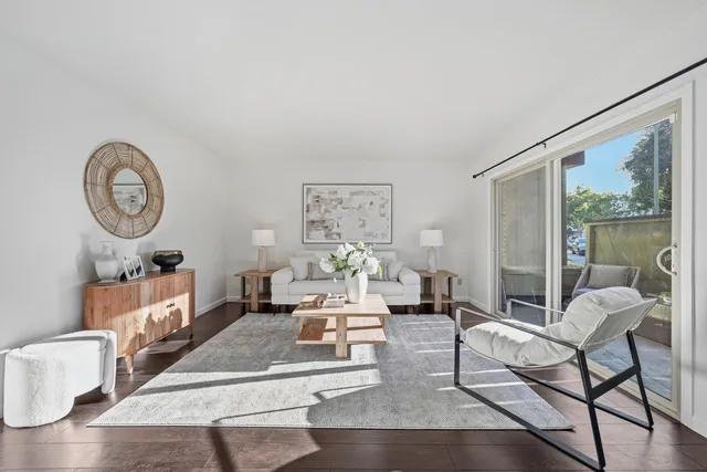 a living room with furniture a clock and a large window
