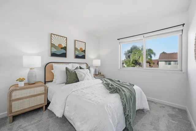 a bedroom with bed and a painting on the wall