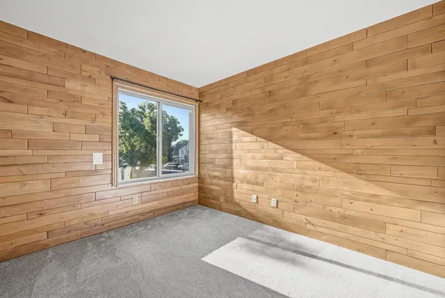 a view of a big room with wooden floor and windows