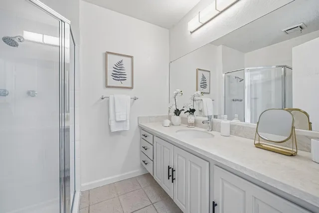 a bathroom with a double vanity sink mirror and shower