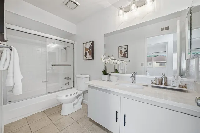 a bathroom with a double vanity sink toilet and shower