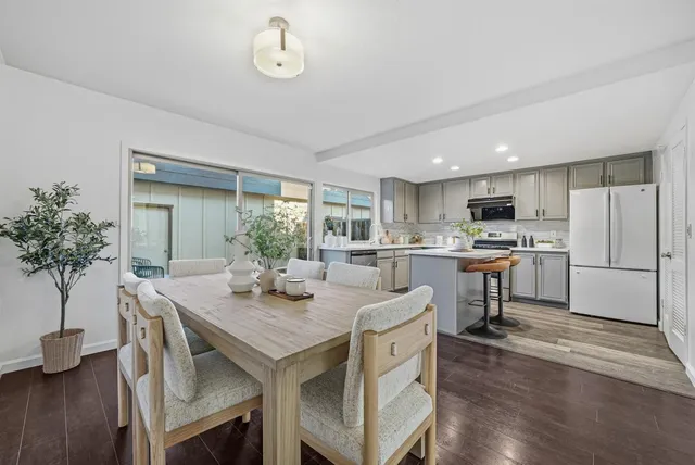 a kitchen with a table chairs refrigerator and microwave