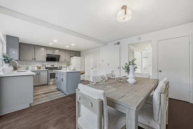 a kitchen with a sink a stove a refrigerator and white cabinets