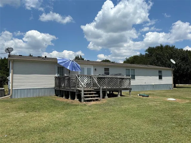 a view of a house with a back yard and a wooden deck