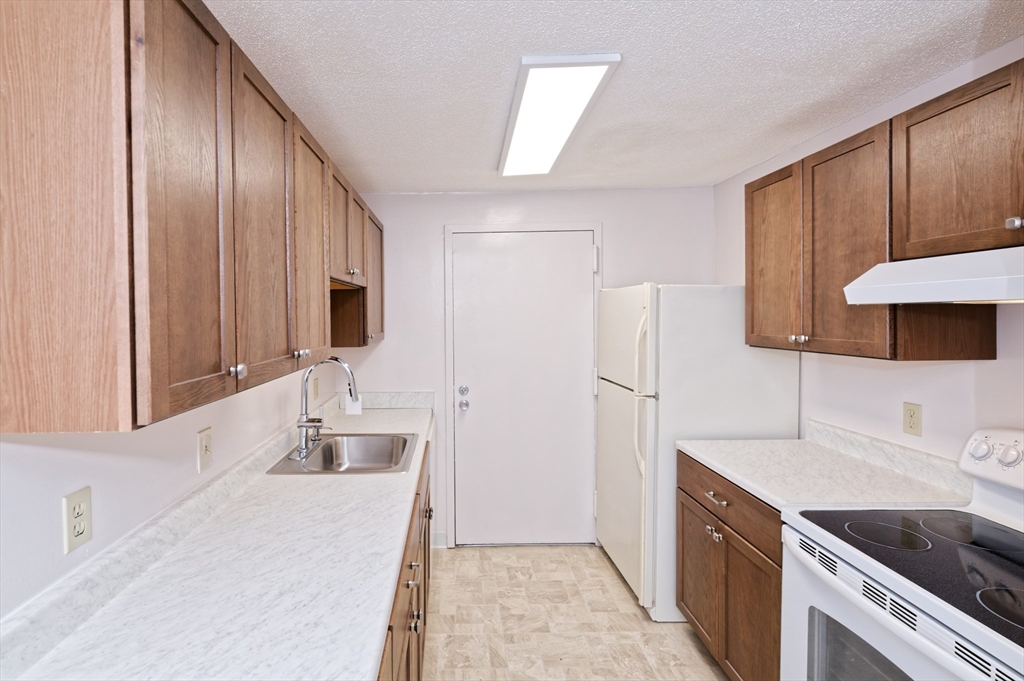 3 Post Oak Lane, Unit 9 Natick, MA 01760 - Photo 12 of 30 a kitchen with a sink and a refrigerator