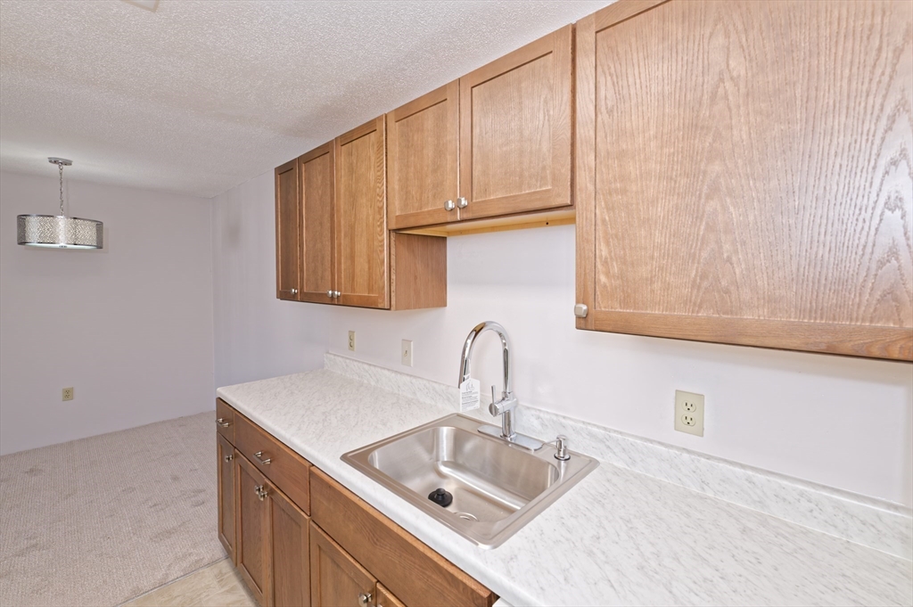 3 Post Oak Lane, Unit 9 Natick, MA 01760 - Photo 13 of 30 a kitchen with a sink cabinets and a wooden floor
