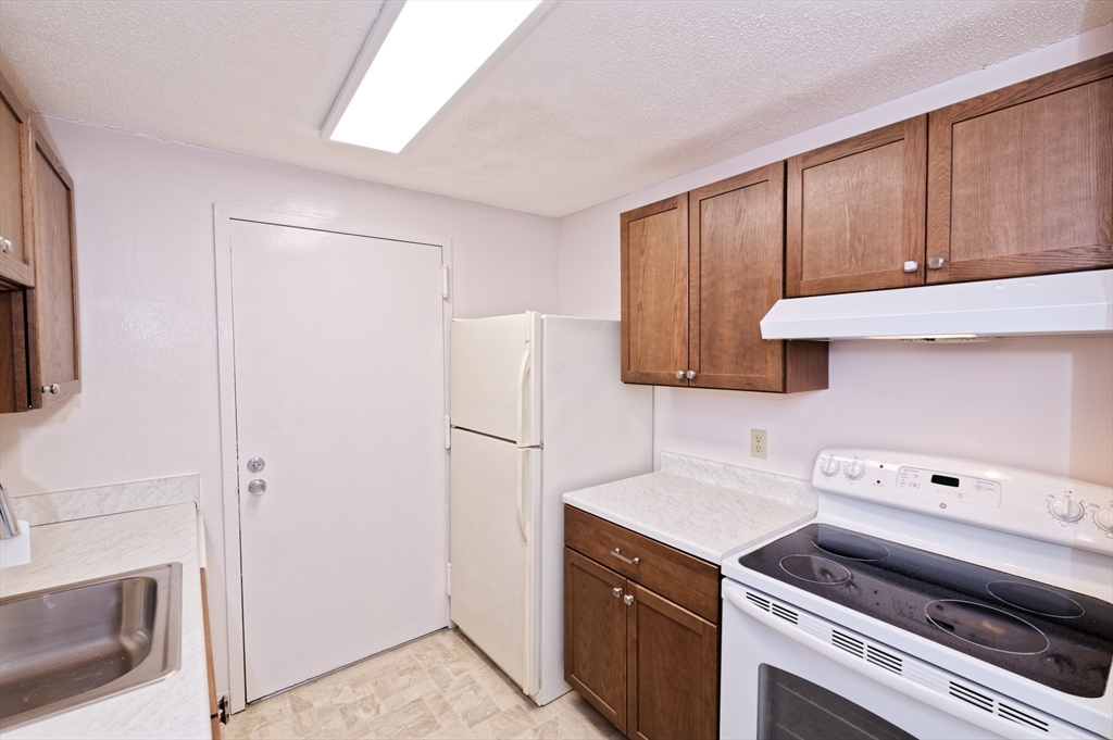 3 Post Oak Lane, Unit 9 Natick, MA 01760 - Photo 14 of 30 a kitchen with a refrigerator sink and cabinets