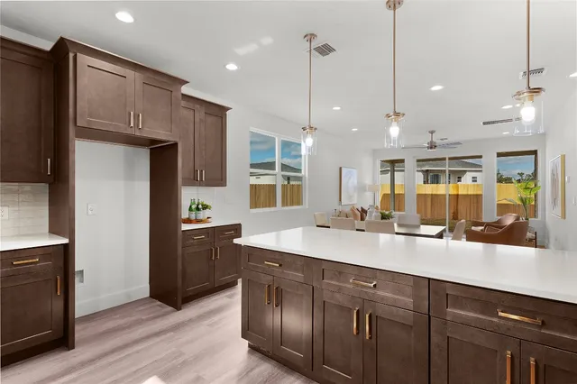 a kitchen with kitchen island granite countertop a sink a counter space appliances and cabinets