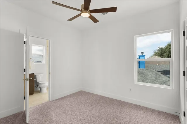 an empty room that has a window and wooden floor