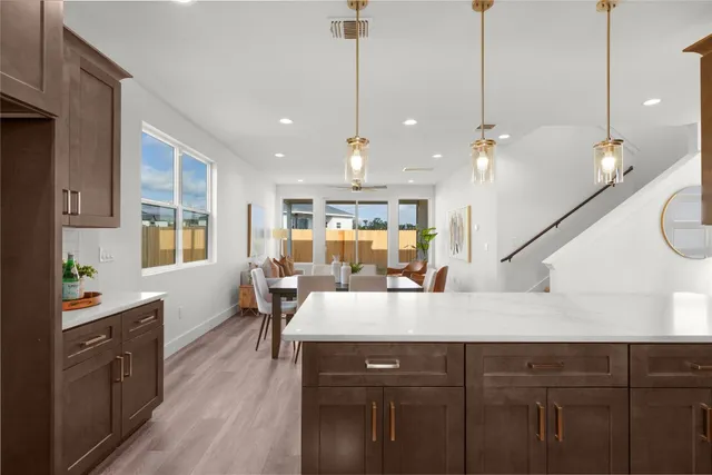 a view of a dining room and livingroom with furniture wooden floor a chandelier