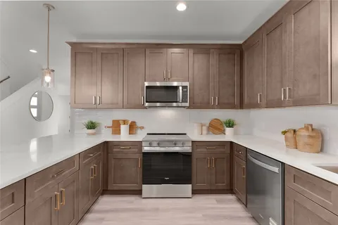 a kitchen with stainless steel appliances granite countertop a stove a sink and a microwave