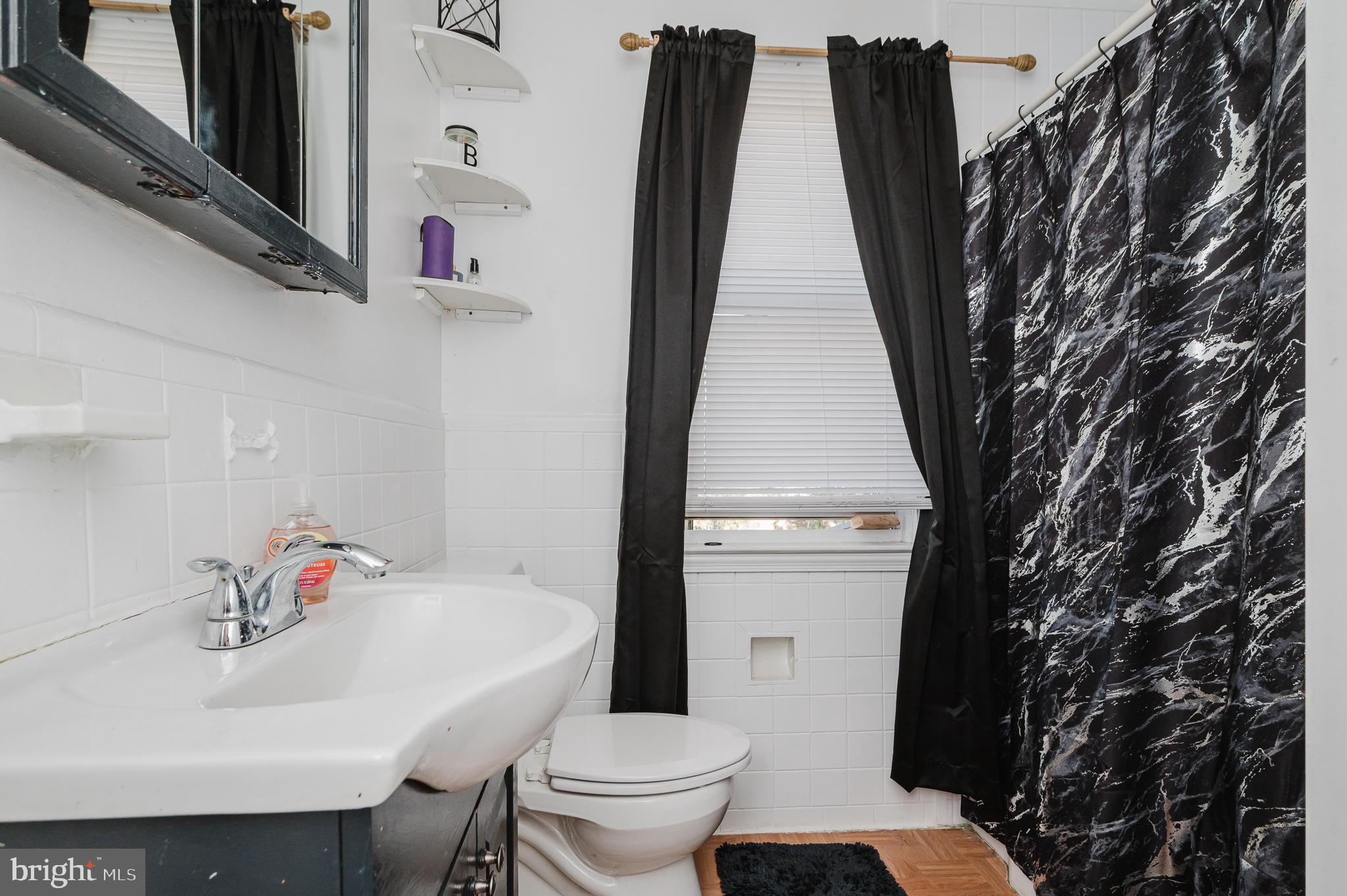 4023 Fallstaff Road Baltimore, MD 21215 - Photo 15 of 22 a bathroom with a sink toilet and a mirror