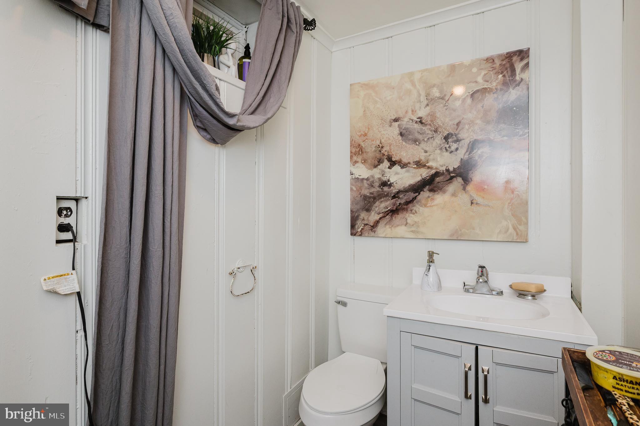 4023 Fallstaff Road Baltimore, MD 21215 - Photo 17 of 22 a bathroom with a toilet a sink and mirror