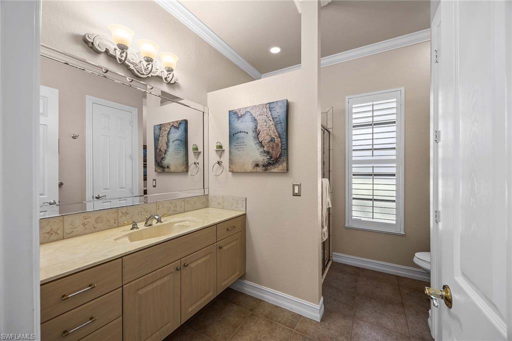 146 Windward Cay Naples, FL 34114 - Photo 21 of 33 a spacious bathroom with a double vanity sink a large mirror a bathtub and window