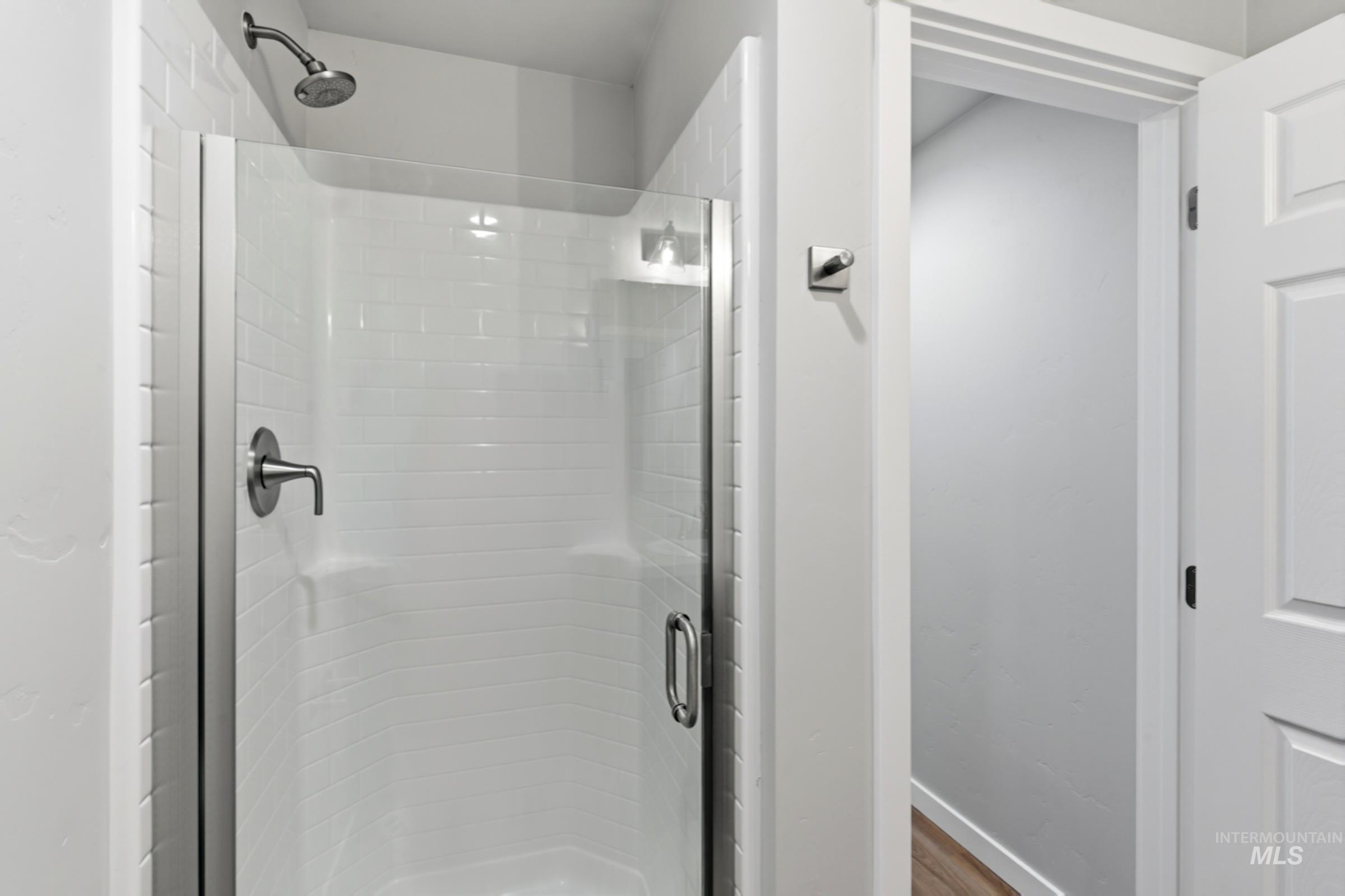 16558 Dunning Way Caldwell, ID 83607 - Photo 15 of 35 Glass-enclosed shower featuring white subway tile, brushed nickel fixtures, and a rain showerhead