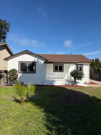 a front view of a house with a garden and yard