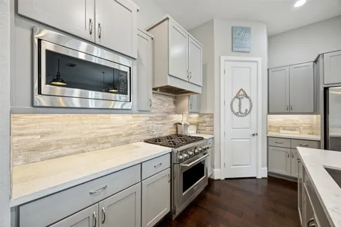 a kitchen with stainless steel appliances granite countertop a stove a microwave and a refrigerator