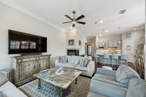 a living room with furniture a flat screen tv and kitchen view