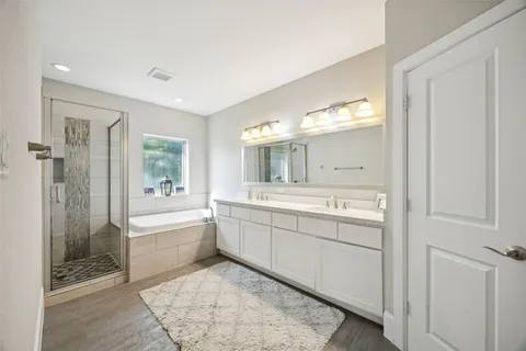 a bathroom with a tub sink shower and mirror