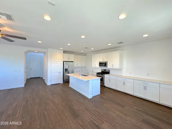a large kitchen with stainless steel appliances granite countertop a large counter top and a floors