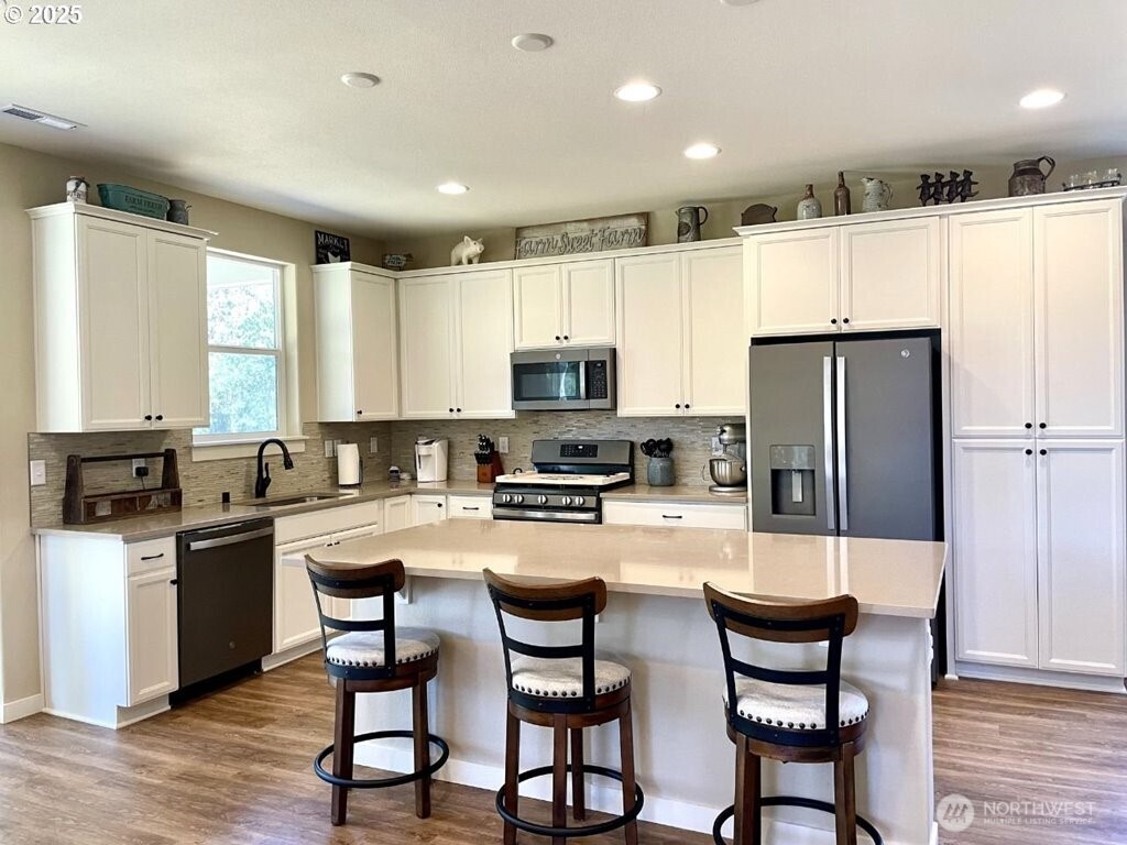 709 North Kemper Loop Ridgefield, WA 98642 - Photo 3 of 25 a kitchen with refrigerator a stove and chairs