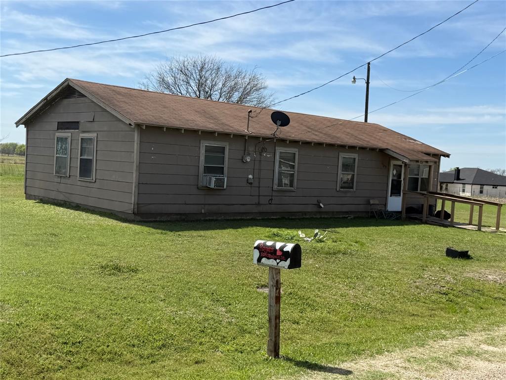 1105 Shabazz Street Milford, TX 76670 - Photo 1 of 6 View of front of house with a front yard and a shingled roof