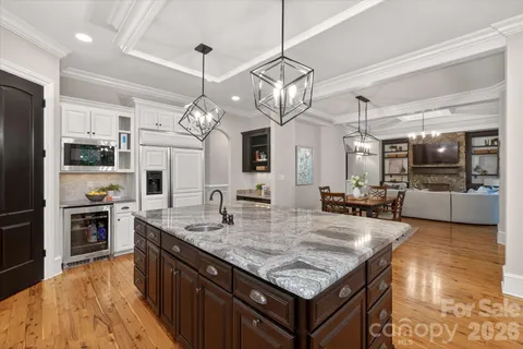 a kitchen with granite countertop a sink a counter top space appliances and cabinets