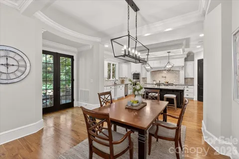 a view of a dining room and livingroom with furniture wooden floor a chandelier