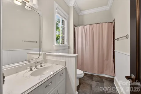 a bathroom with a sink a toilet and a mirror