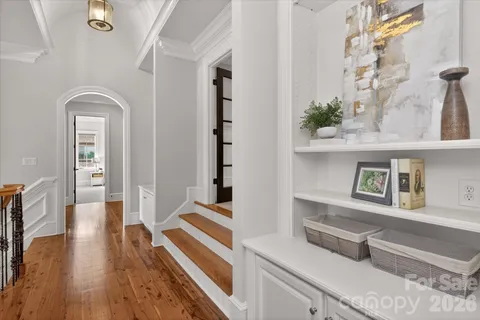 a view of a hallway with wooden floor and staircase