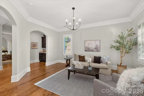 a living room with furniture a chandelier and a rug