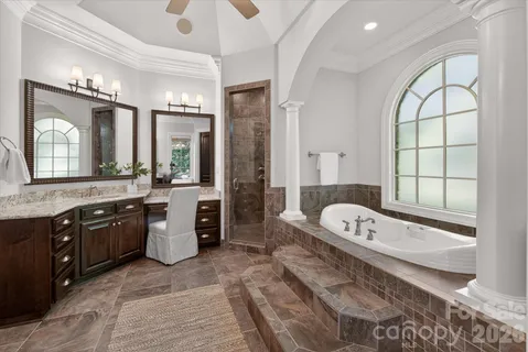 a large spacious bathroom with a tub a double vanity sink a mirror a window and a shower