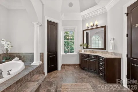 a spacious bathroom with a granite countertop sink and a mirror