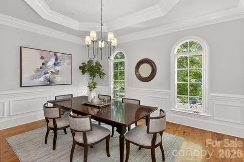 a dining room with furniture a large window and a chandelier