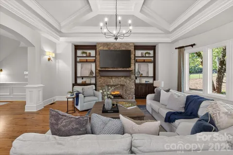 a living room with furniture a chandelier and a large window
