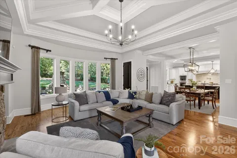 a living room with furniture chandelier and a large window