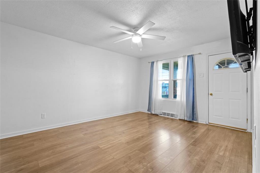 3144 Leechburg Road Lower Burrell, PA 15068 - Photo 12 of 47 a view of an empty room with wooden floor and a window