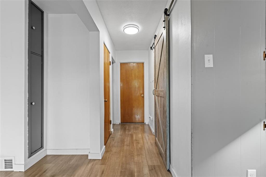 3144 Leechburg Road Lower Burrell, PA 15068 - Photo 16 of 47 a view of a hallway with wooden floor and a mirror
