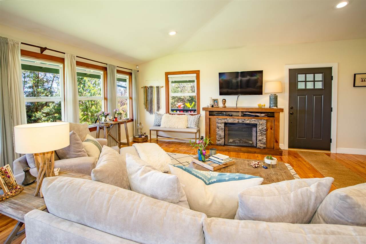 180 Waiakoa Road Kula, HI 96790 - Photo 9 of 27 a living room with furniture flat screen tv and a fireplace
