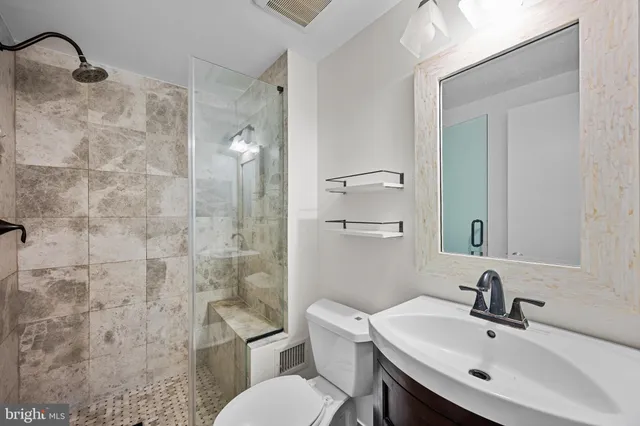 a bathroom with a sink a toilet and shower