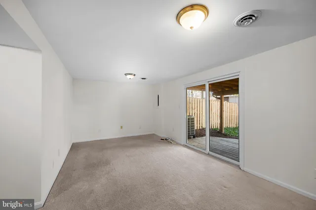 an empty room with sliding door and windows