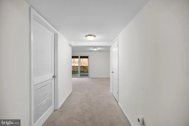 a view of a hallway with wooden shelves