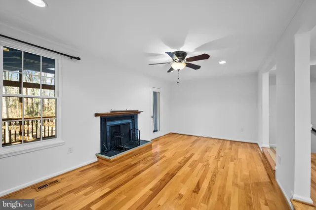 a view of an empty room with a fireplace and a window
