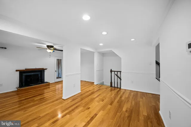 a view of empty room with a fireplace and wooden floor