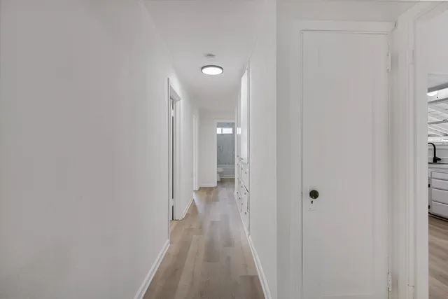 a view of a room with wooden floor and a bathroom
